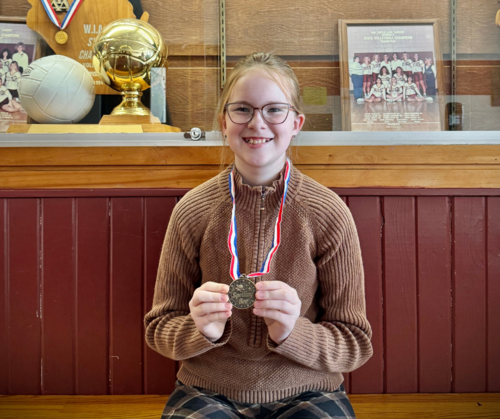 Johanna holding up her medal from the Spelling Bee